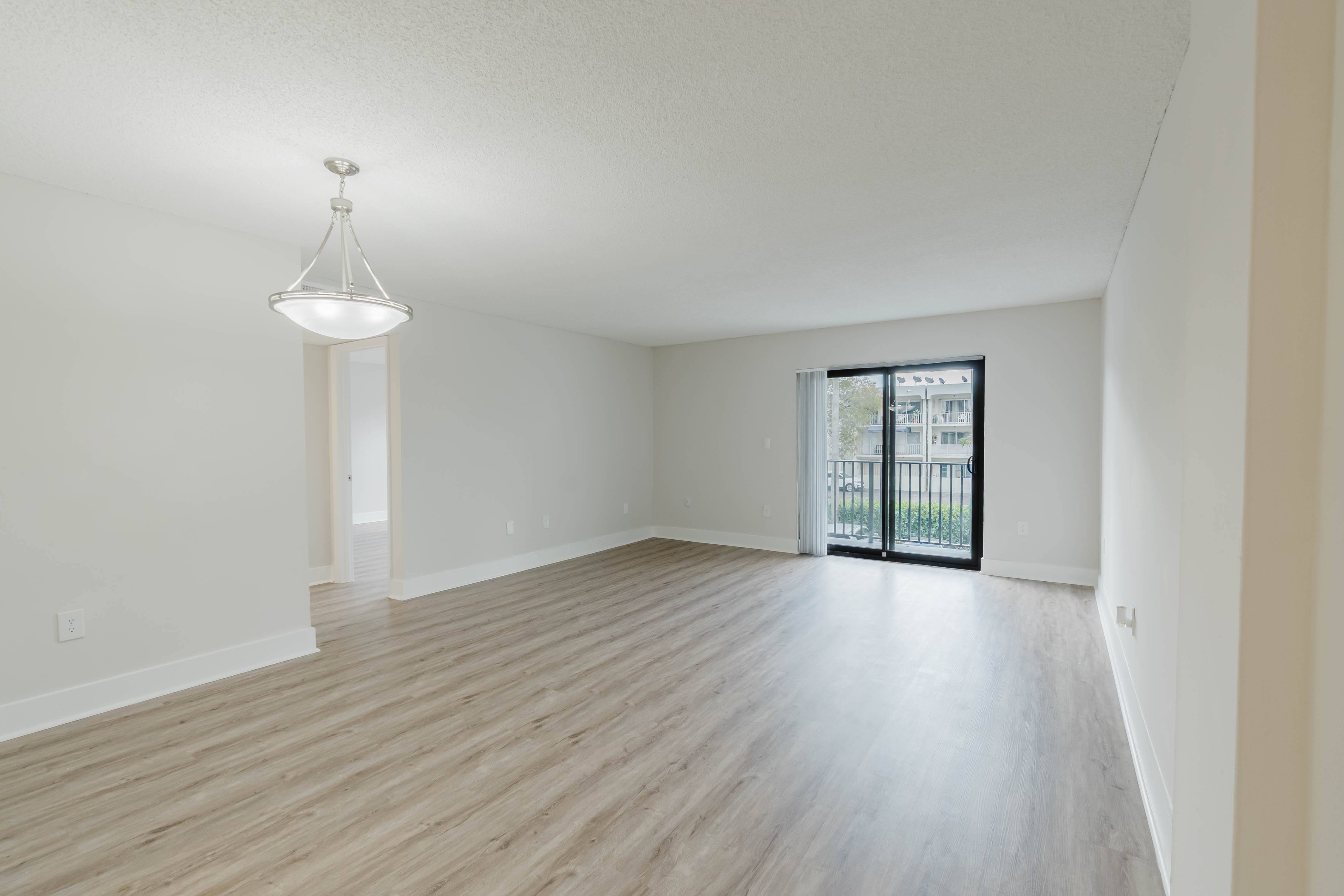 A room with wooden flooring and a chandelier.